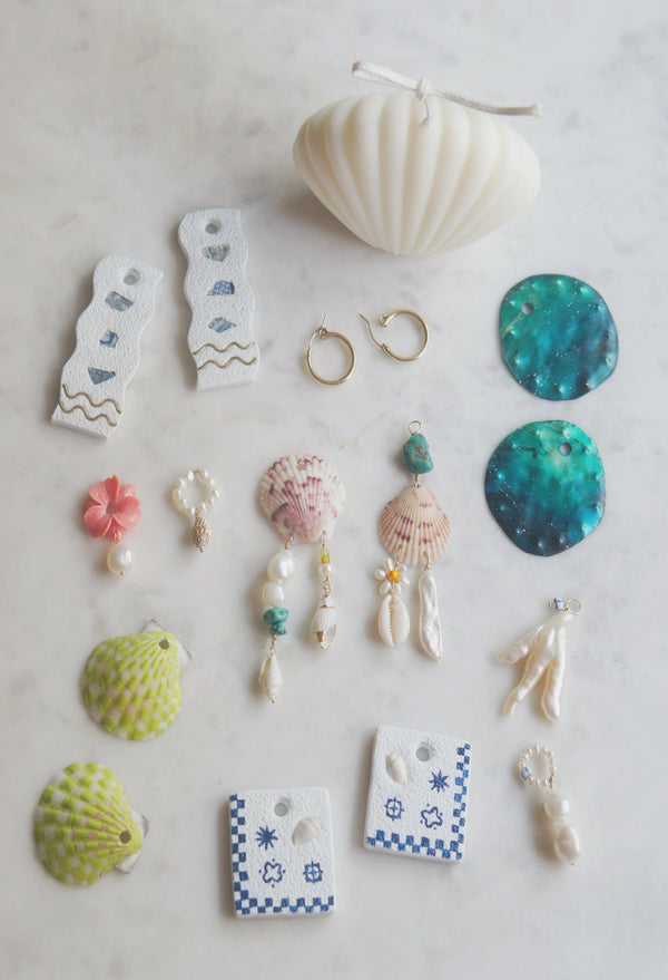 Lime green handpainted shell earrings in a checkered pattern next to other available charms and earrings