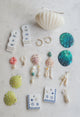 Lime green handpainted shell earrings in a checkered pattern next to other available charms and earrings