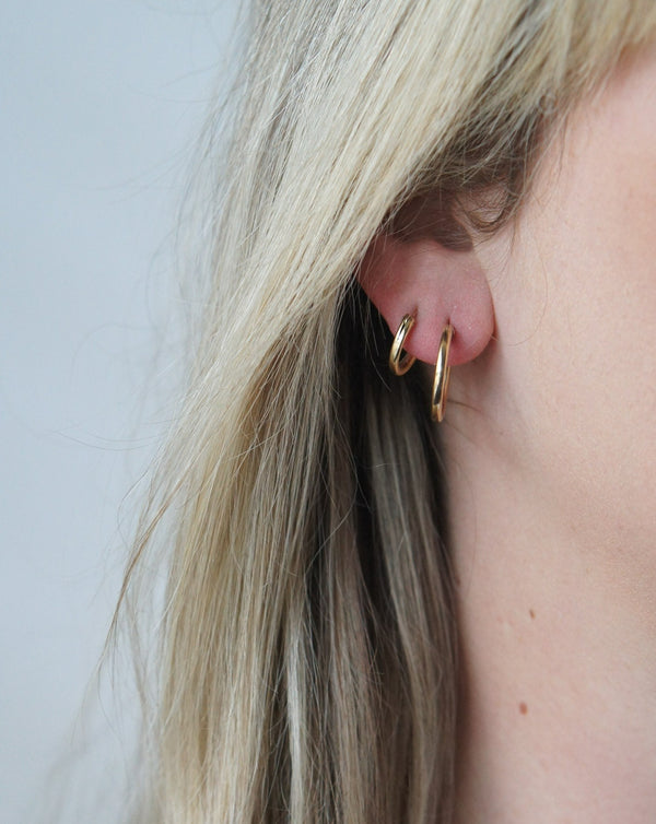 close up of both size earrings in one ear