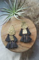 Hammered gold and black tassle earrings on wood circle