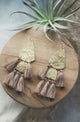 Hammered gold and medium brown tassle earrings on wood