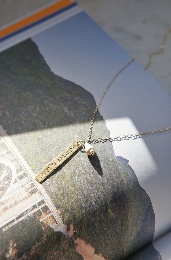 close up of happy place necklace laid on book