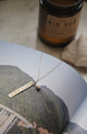 close up of happy place necklace laid on book